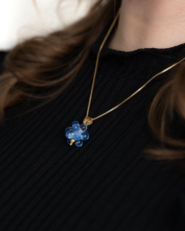 Sovituskuva kultaisesta kaulakorusta sinisillä helmillä