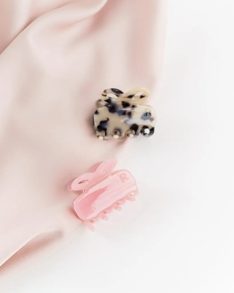 Kaksi eriväristä pientä hiusklipsiä vaalealla taustalla