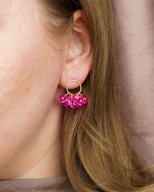 Sovituskuva kultaisista nappikorvakoruista joissa pinkkejä helmiä